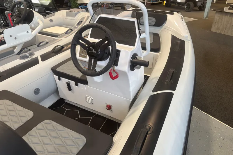Slide: The Image of 2026 Highfield Sport 360 boat interior with steering wheel and seating. - 1