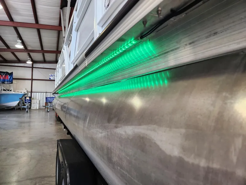 Slide: The Image of Side view of a Veranda VTX 25RC pontoon boat with green LED lighting. - 18