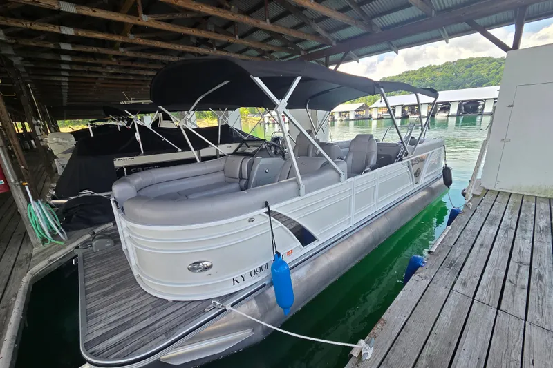 Slide: The Image of 2019 Veranda VTX 25RC pontoon boat docked under a wooden shelter. - 12