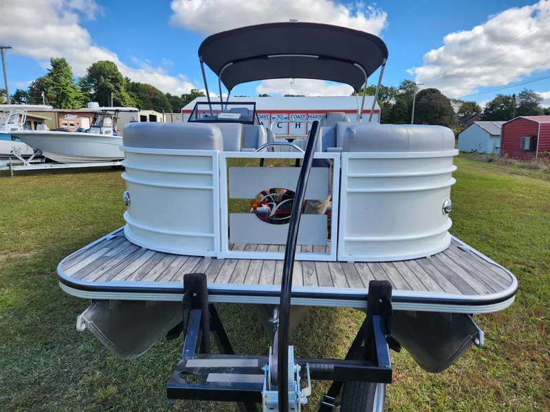 Slide: The Image of A 2019 Veranda VTX 25RC pontoon boat on a trailer in a grassy area. - 2