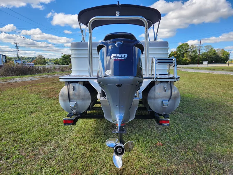 Slide: The Image of A 2019 Veranda VTX 25RC pontoon boat with a powerful outboard motor, parked on grass. - 3