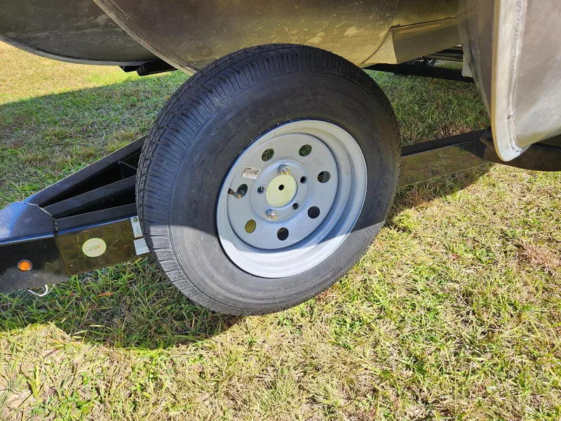 Slide: The Image of A boat trailer with a wheel parked on grass. - 16