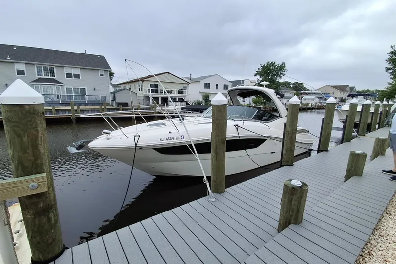 Slide: The Image of 2016 Sea Ray Sundancer 330 docked at a marina with waterfront homes in the background. - 1