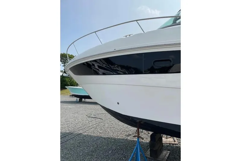 Slide: The Image of 2016 Sea Ray Sundancer 330 yacht on dry dock, showcasing sleek white hull design. - 5