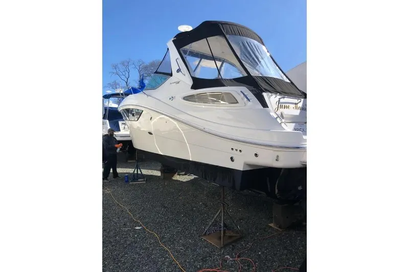Slide: The Image of 2016 Sea Ray Sundancer 330 yacht on stands, with a black canopy, outdoors. - 3