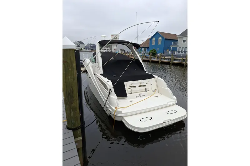 Slide: The Image of 2016 Sea Ray Sundancer 330 docked, rear view with covered deck, in a marina setting. - 2