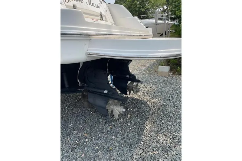 Slide: The Image of 2016 Sea Ray Sundancer 330 boat stern view with dual propellers on gravel surface. - 6