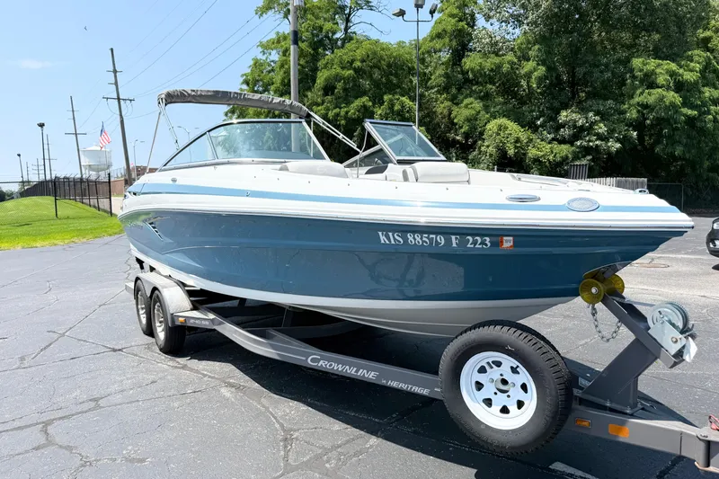 The Image of 2023 Crownline 240 SS boat on trailer, parked outdoors on a sunny day. - 0
