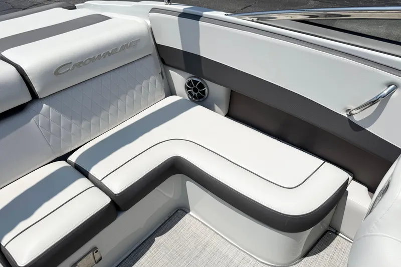 Slide: The Image of 2023 Crownline 240 SS boat interior with white cushioned seating and speaker. - 8