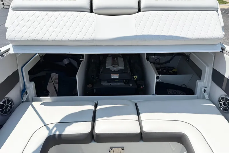 Slide: The Image of 2023 Crownline 240 SS boat engine compartment with cushioned seating and storage areas. - 10