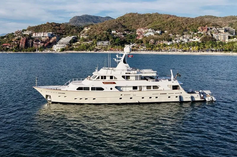 Slide: The Image of Luxurious 1988 Sterling 137 yacht anchored near scenic coastal landscape. - 1