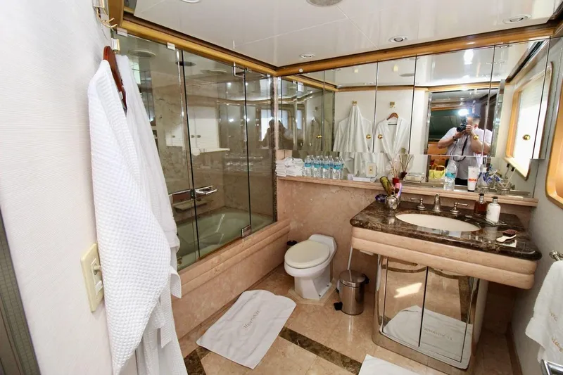 Slide: The Image of Luxurious yacht bathroom with marble sink, glass shower, and plush robes, Sterling 137, 1988 model. - 9