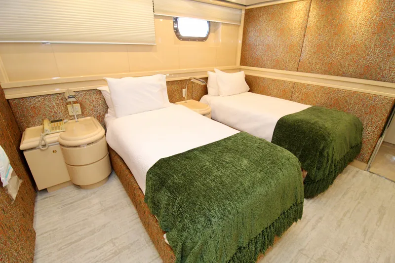 Slide: The Image of Twin beds with green blankets in a 1988 Sterling 137 yacht cabin. - 17