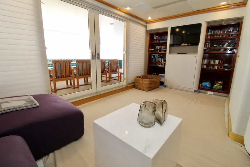 Slide: The Image of Luxurious yacht interior with modern decor, featuring a lounge area, bookshelves, and outdoor dining space. - 25