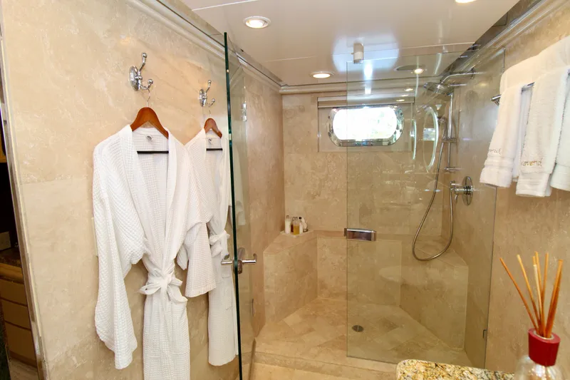 Slide: The Image of Luxurious yacht bathroom with glass shower, plush robes, and elegant marble decor, Sterling 137, 1988. - 13