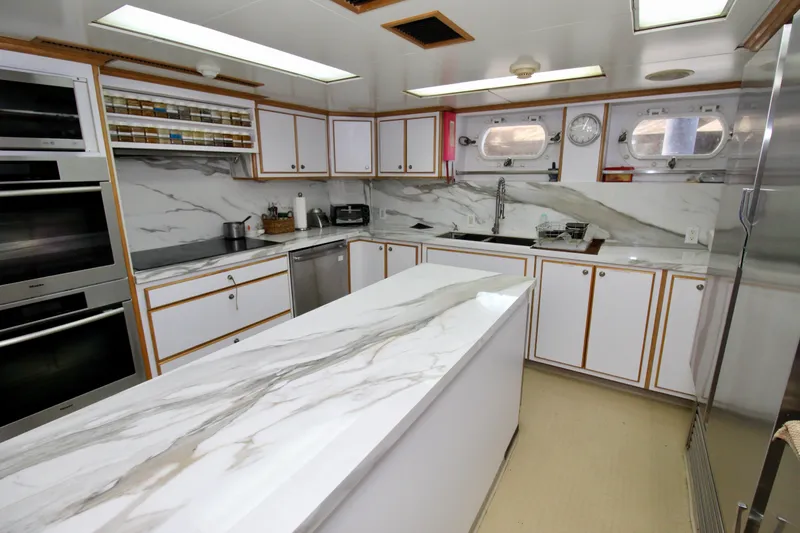Slide: The Image of Luxurious yacht kitchen with marble countertops, modern appliances, and ample storage, 1988 Sterling 137. - 19