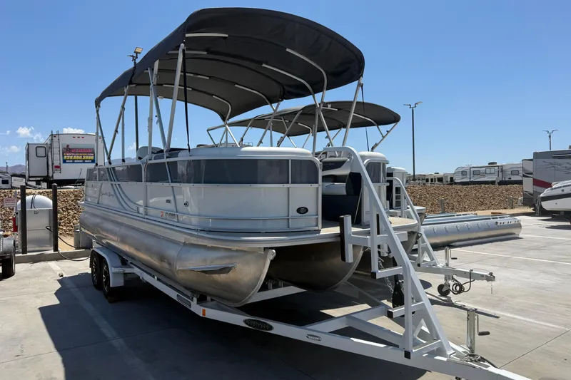 The Image of 2022 South Bay 224CR2 pontoon boat on trailer in sunny outdoor setting. - 1