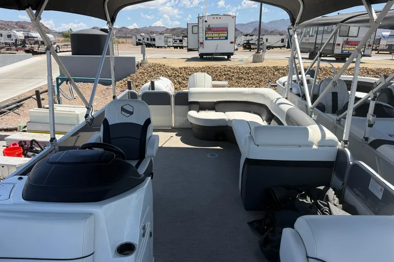 Slide: The Image of 2022 South Bay 224CR2 pontoon boat interior with seating and canopy in a marina setting. - 6