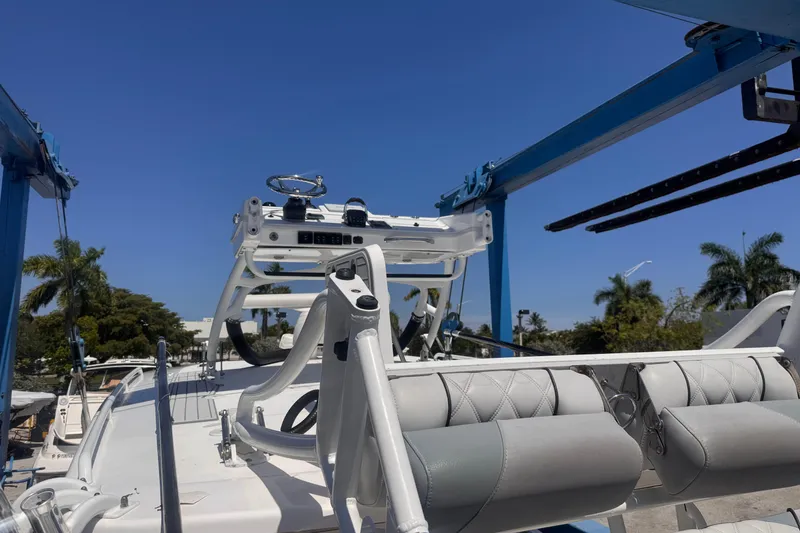 Slide: The Image of 2016 Everglades 435 Center Console boat under blue sky, featuring helm and seating area. - 27