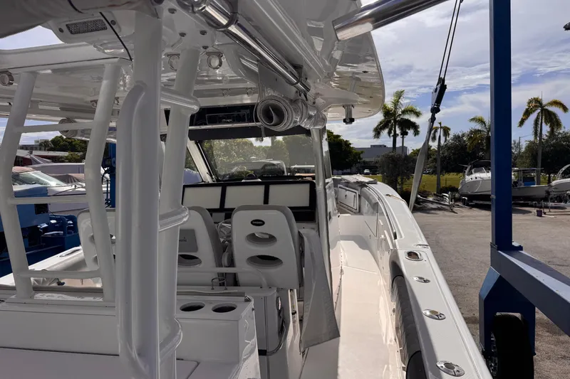 Slide: The Image of 2016 Everglades 435 Center Console boat interior with helm and seating, docked outdoors. - 11
