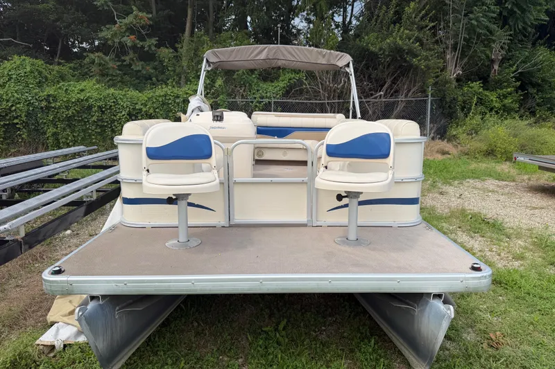 Slide: The Image of 2004 Sweetwater Challenger 200 RE-4 Gate pontoon boat with dual seats, parked on grass. - 5