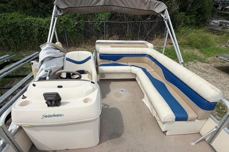 Slide: The Image of 2004 Sweetwater Challenger 200 RE-4 Gate pontoon boat with beige and blue seating. - 11