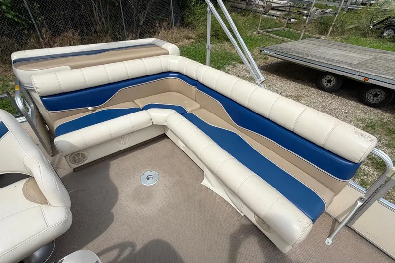 Slide: The Image of 2004 Sweetwater Challenger 200 RE-4 Gate boat seating, featuring beige and blue upholstery. - 12