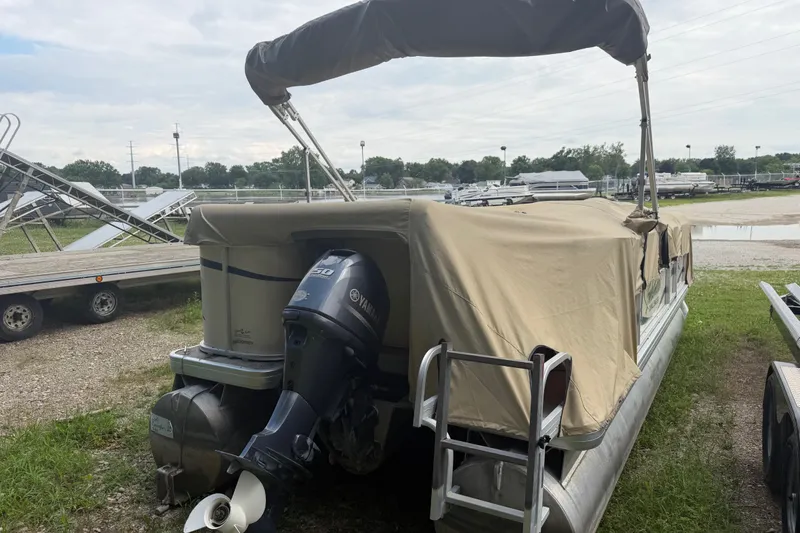 Slide: The Image of 2004 Sweetwater Challenger 200 RE-4 Gate pontoon boat with Yamaha motor, covered and parked outdoors. - 4
