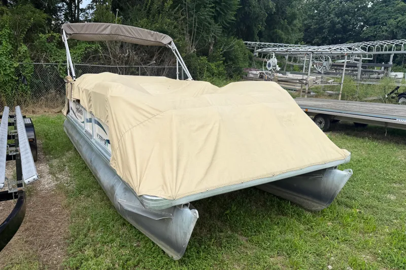 The Image of 2004 Sweetwater Challenger 200 RE-4 Gate pontoon boat covered, parked on grass. - 1