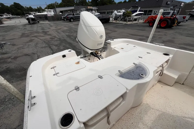 Slide: The Image of 2018 Carolina Skiff 198 DLV boat with Suzuki outboard motor in a marina setting. - 6