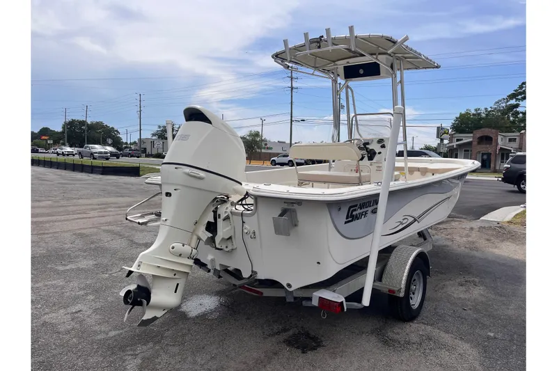 Slide: The Image of 2018 Carolina Skiff 198 DLV boat on trailer, featuring outboard motor and T-top. - 5