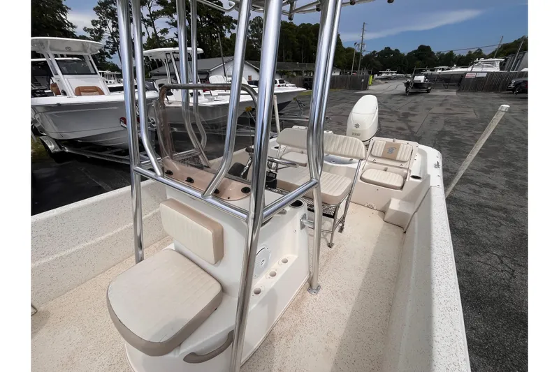 Slide: The Image of 2018 Carolina Skiff 198 DLV boat interior with seating and console, parked outdoors. - 13