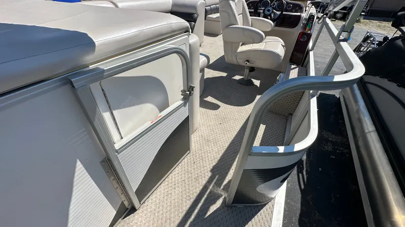 Slide: The Image of Interior of a 2008 Manitou Legacy pontoon boat with beige seating and carpeted flooring. - 6