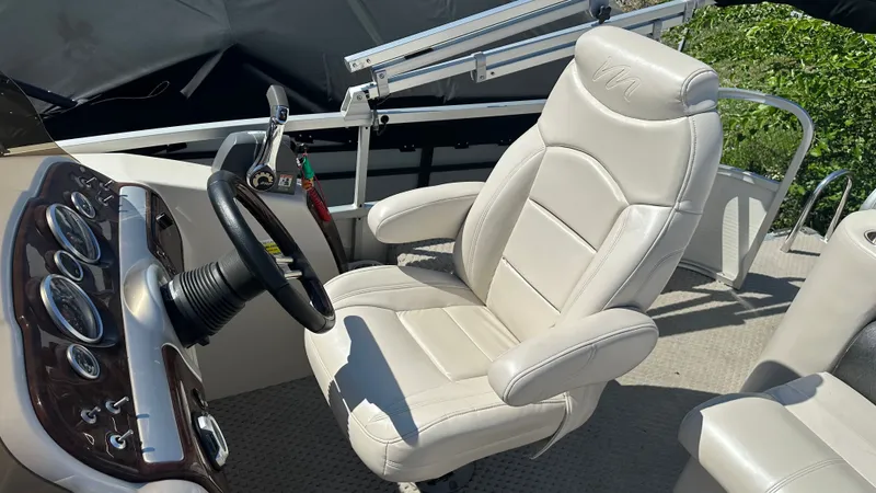 Slide: The Image of The image shows the helm of a 2008 Manitou Legacy boat with a comfortable captain's chair. - 11