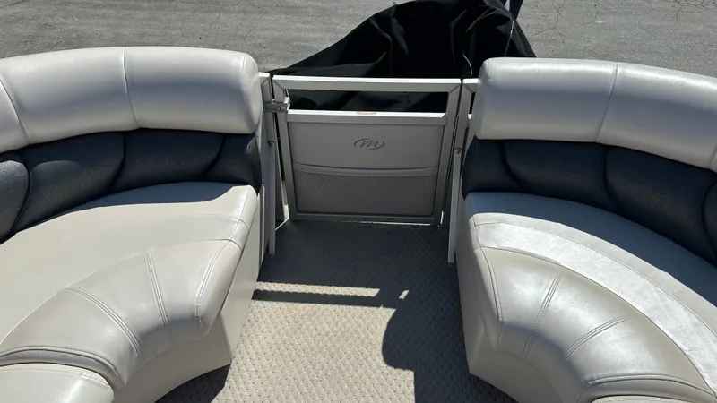 Slide: The Image of The image shows the interior of a 2008 Manitou Legacy pontoon boat with beige and gray seating. - 20