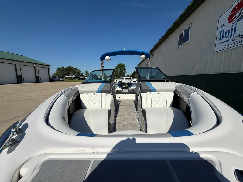 Slide: The Image of A 2019 Regal 23 RX Bowrider is parked. It features white and blue upholstery. - 3