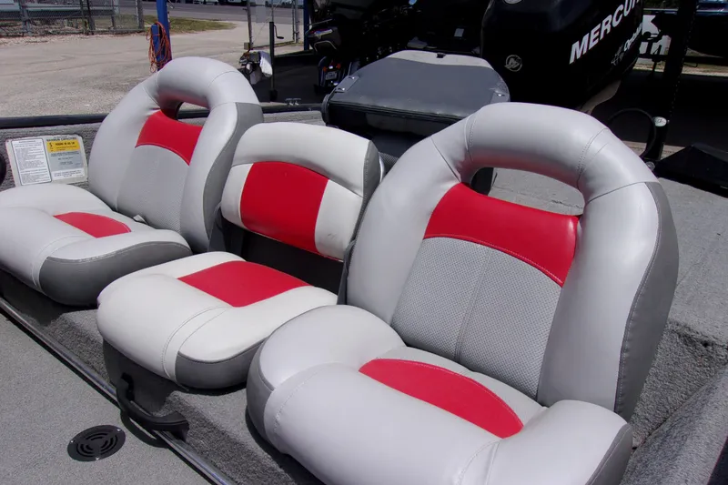 Slide: The Image of 2013 Tracker Pro Team 190 TX boat seats with red and gray upholstery. - 7