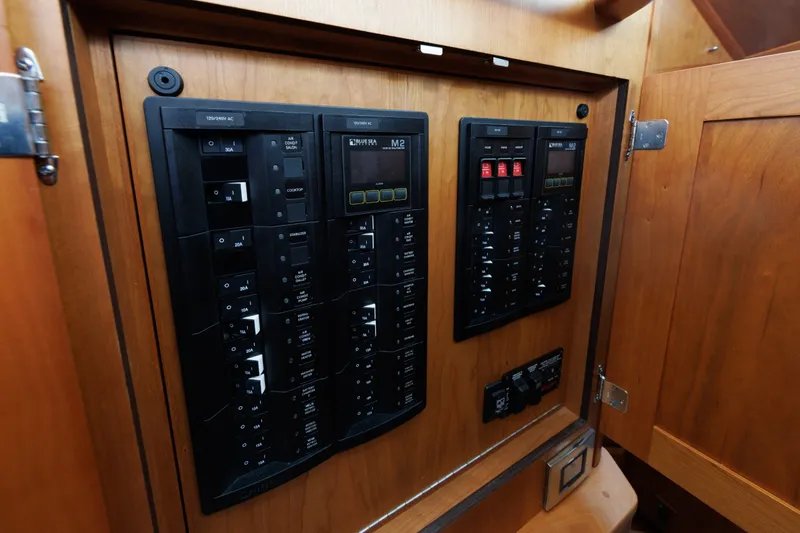 Slide: The Image of Electrical panel inside 2024 Sabre 48 Salon Express yacht, featuring circuit breakers and switches. - 27