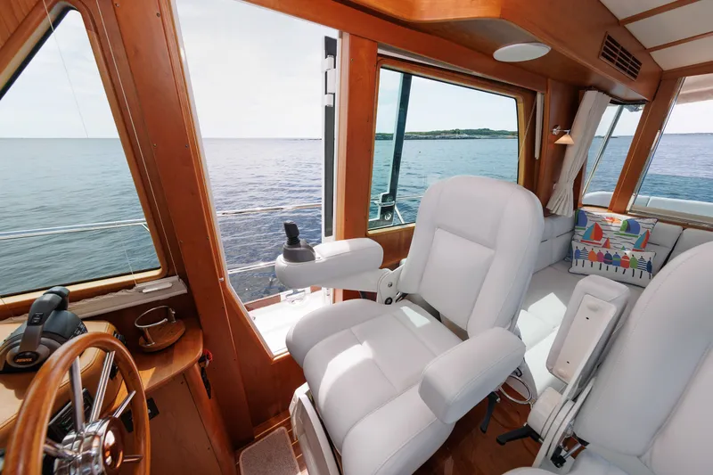 Slide: The Image of 2024 Sabre 48 Salon Express interior with ocean view, featuring luxurious white seating and wooden accents. - 20