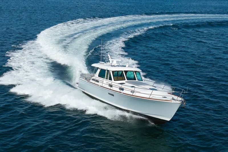 Slide: The Image of 2024 Sabre 48 Salon Express cruising on open water, creating a dynamic wake. - 8