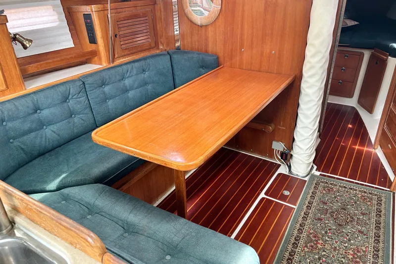 Slide: The Image of Interior of 1998 Catalina 36 MkII sailboat with wooden table and cushioned seating. - 44