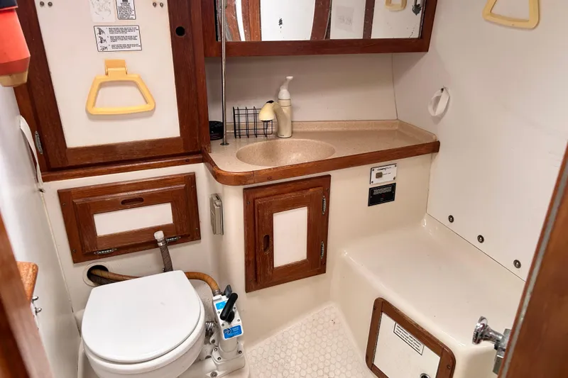 Slide: The Image of Bathroom of a 1998 Catalina 36 MkII sailboat with wooden cabinetry and compact fixtures. - 62