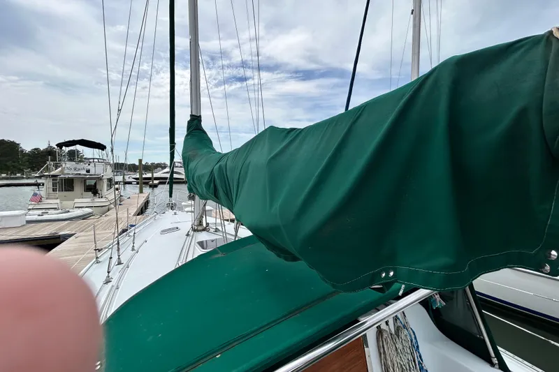 Slide: The Image of 1998 Catalina 36 MkII sailboat docked, green sail cover, marina background. - 9