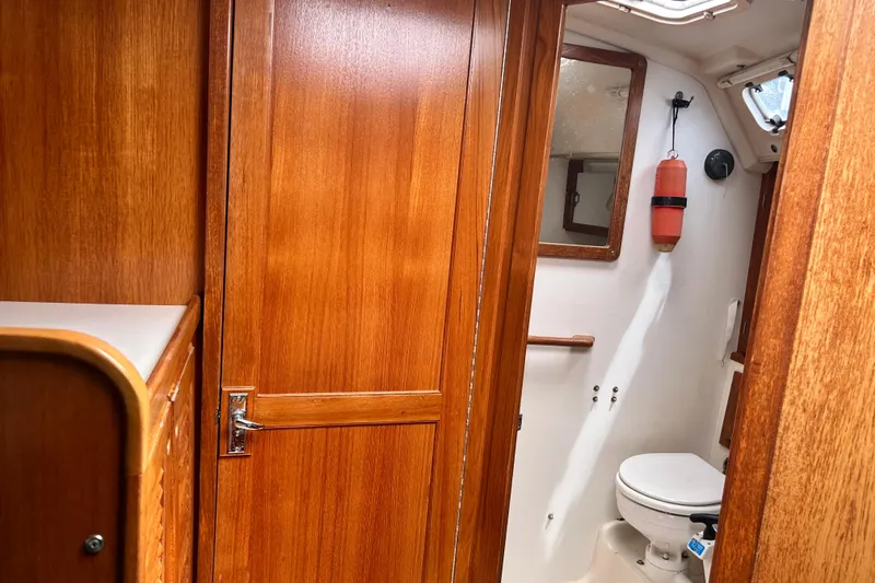 Slide: The Image of Interior of 1998 Catalina 36 MkII sailboat, featuring wooden cabinetry and compact bathroom. - 83
