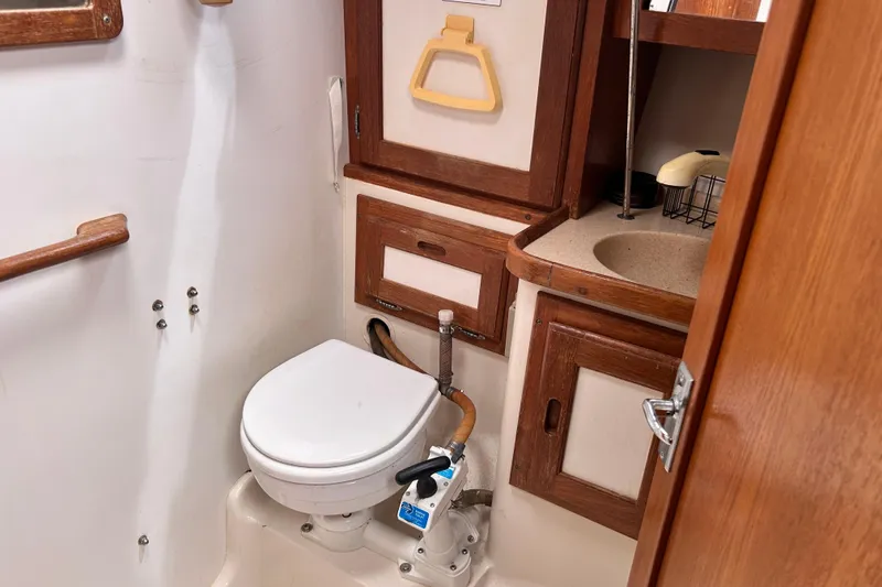 Slide: The Image of 1998 Catalina 36 MkII yacht bathroom with toilet, sink, and wooden cabinetry. - 84