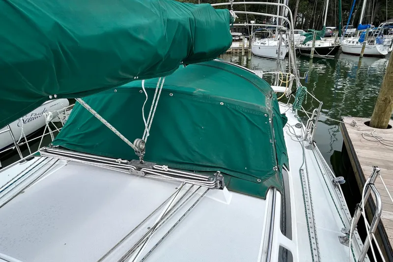 Slide: The Image of 1998 Catalina 36 MkII sailboat with green covers docked at a marina. - 13