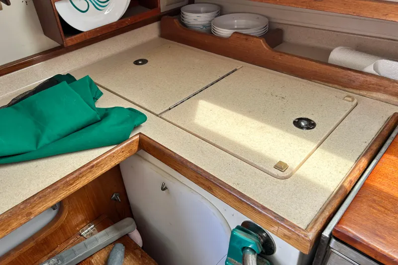 Slide: The Image of Galley countertop in a 1998 Catalina 36 MkII sailboat with storage and dishes. - 55