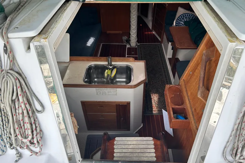 Slide: The Image of Interior view of a 1998 Catalina 36 MkII sailboat, featuring a compact kitchen area. - 34