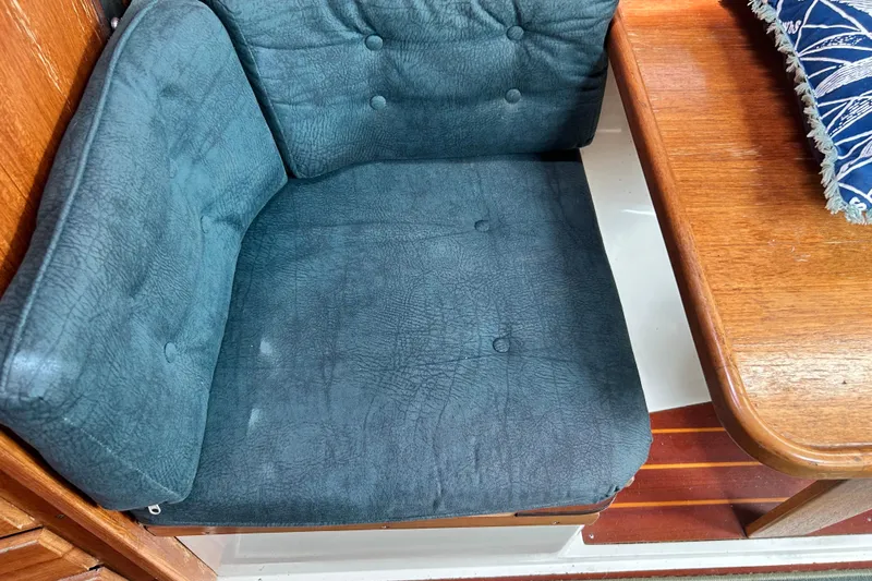 Slide: The Image of Blue cushioned seat and wooden table inside a 1998 Catalina 36 MkII sailboat. - 54