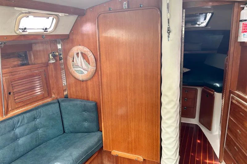 Slide: The Image of Interior of a 1998 Catalina 36 MkII sailboat with wooden cabinetry and blue seating. - 45